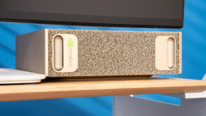 NVIDIA DGX Spark de sobremesa con carcasa dorada perforada, situado bajo un monitor.